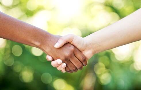 Two people shaking hands outdoors
